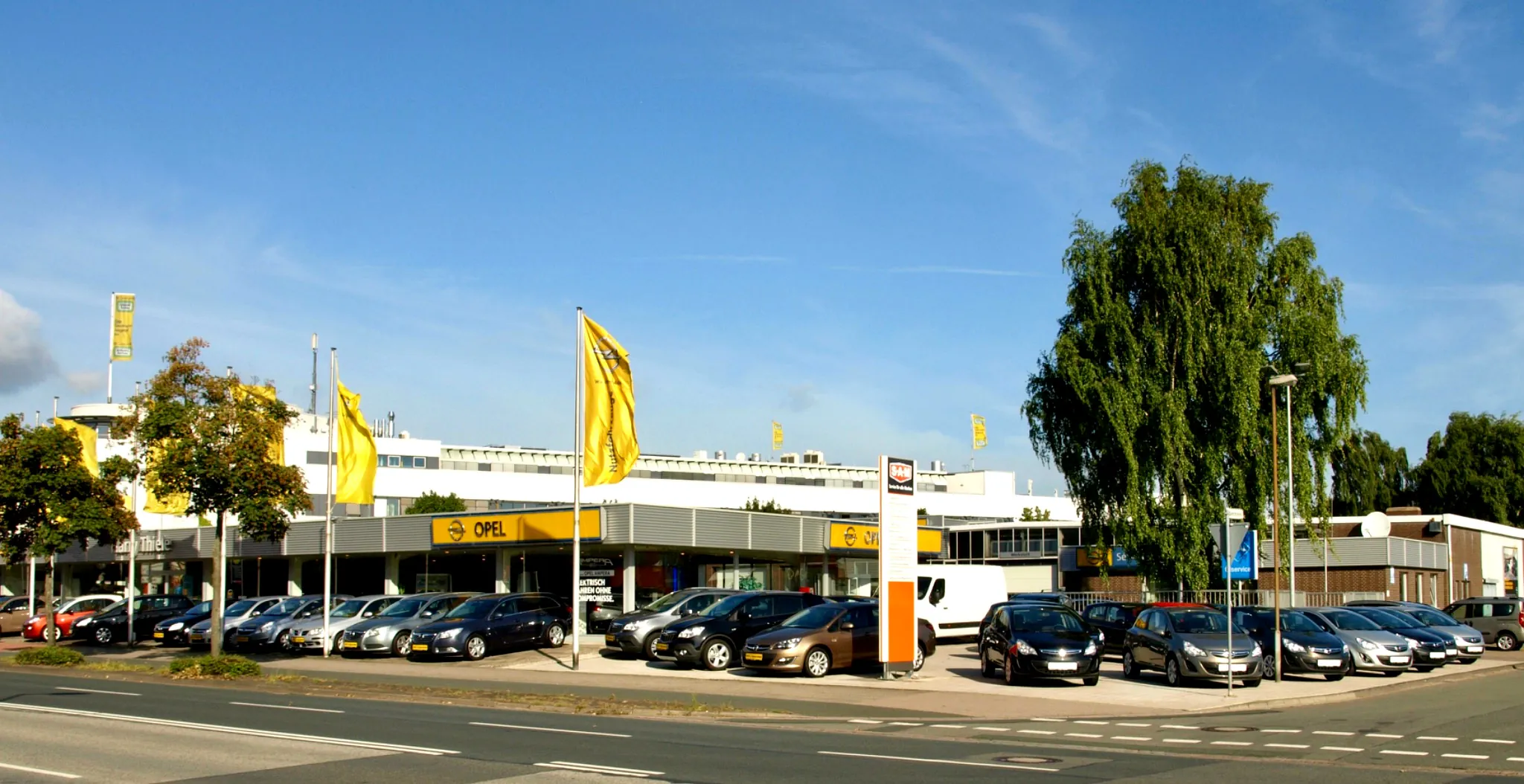 Das Autohaus Harry Thiele in Garbsen mit Opel-Fahnen und Fahrzeugausstellung
