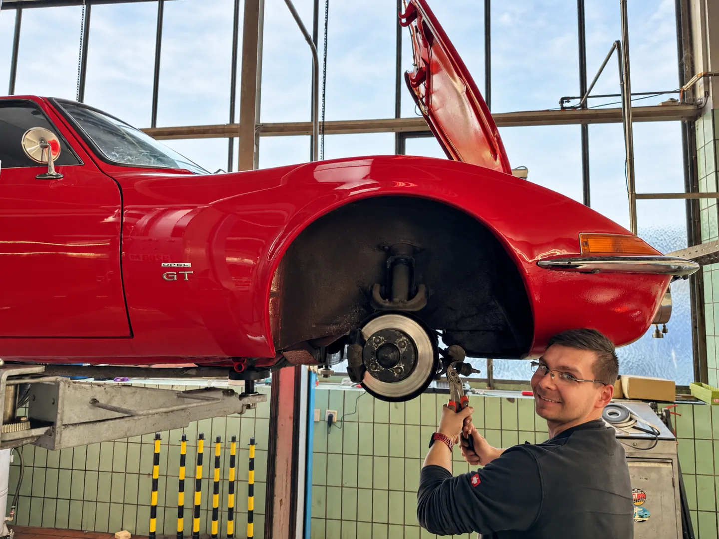 Opel GT auf der Hebebühne mit Mechaniker in der Werkstatt